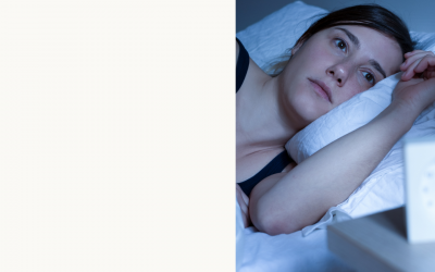 Woman lying in bed wide awake close to midnight
